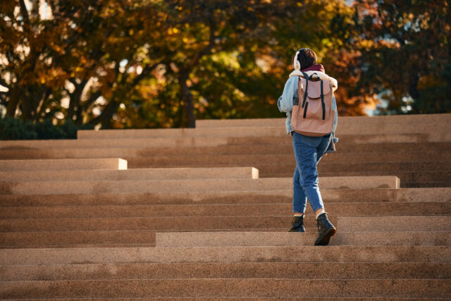 photo - Female Student Walking Up the Staircase Outdoors