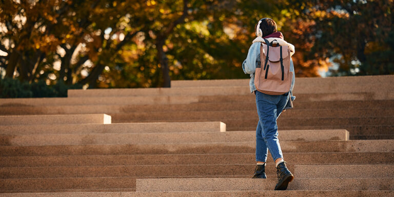 photo - Female Student Walking Up the Staircase Outdoors