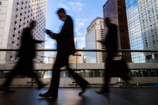 photo - Blurred Silhouettes of Businesspeople Walking