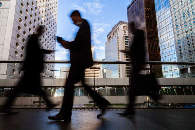 photo - Blurred Silhouettes of Businesspeople Walking