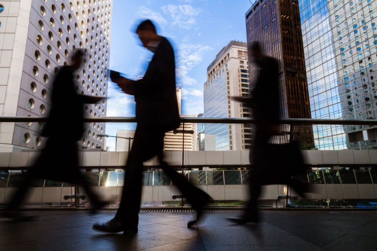photo - Blurred Silhouettes of Businesspeople Walking
