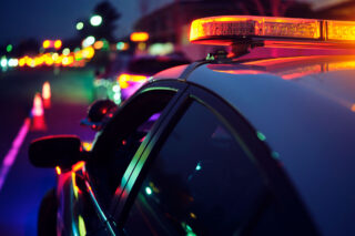 photo - Police car stopping a vehicle at night