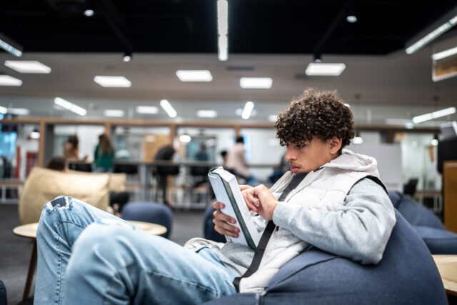 photo - Young University Student Man Reading a Book