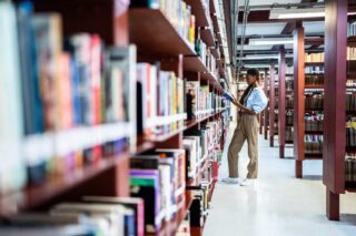 photo - Young Woman Searching Books in the Library