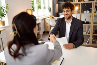 photo - Male Candidate Handshakes with Female Recruiter in Office during Job Interview
