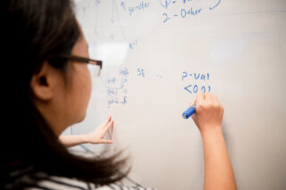 photo - Student Tries To Solve a Math Problem on Whiteboard