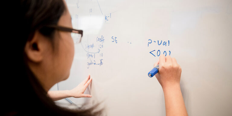 photo - Student Tries To Solve a Math Problem on Whiteboard