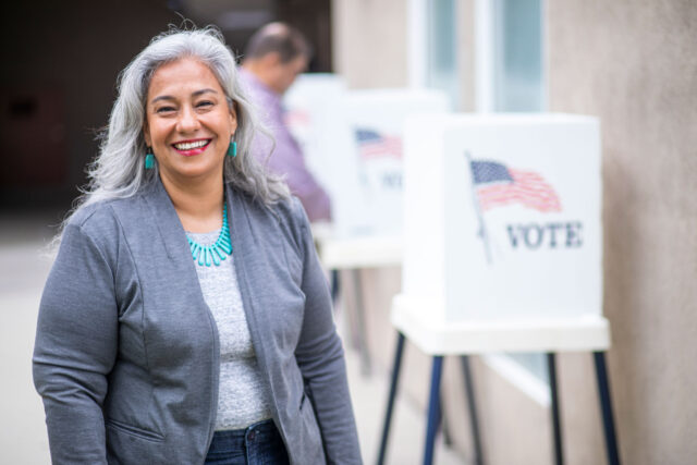 photo - Woman Looking at Camera and Smiling after Voting