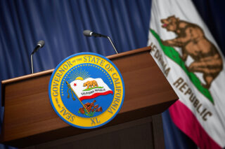 photo - Seal of the Governor of the State of California on a Podium and California State Flag