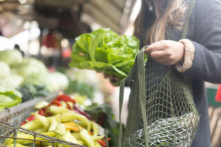 photo - Woman shopping for produce using reusable bag