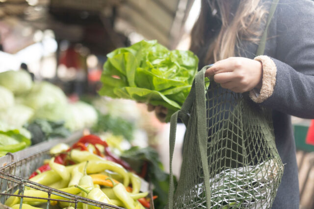 photo - Woman shopping for produce using reusable bag