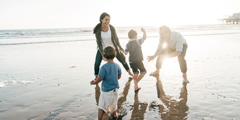 photo - Parents Playing with Kids on the Beach