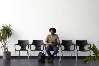 photo - One Man Sitting on a Row of Chairs Awaiting a Job Interview
