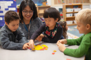 photo - Teacher with Multiracial Preschool Kindergarten Students Learning with Puzzle Toy in Classroom
