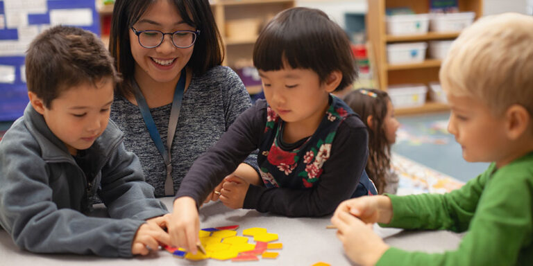 photo - Teacher with Multiracial Preschool Kindergarten Students Learning with Puzzle Toy in Classroom
