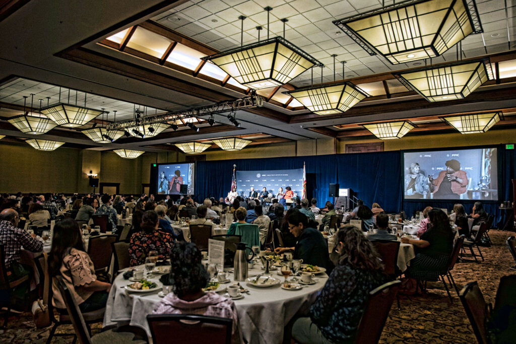 The audience listens attentively to the speakers.