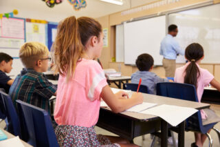 photo - Teacher writing on board in class