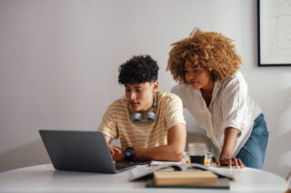 photo - Teenage Boy on Laptop with Mother Looking over Shoulder