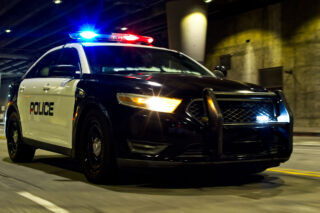 photo - Police car driving with sirens on in an underpass in downtown Los Angeles, California
