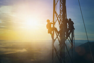photo - Silhouette of electricians work on high ground