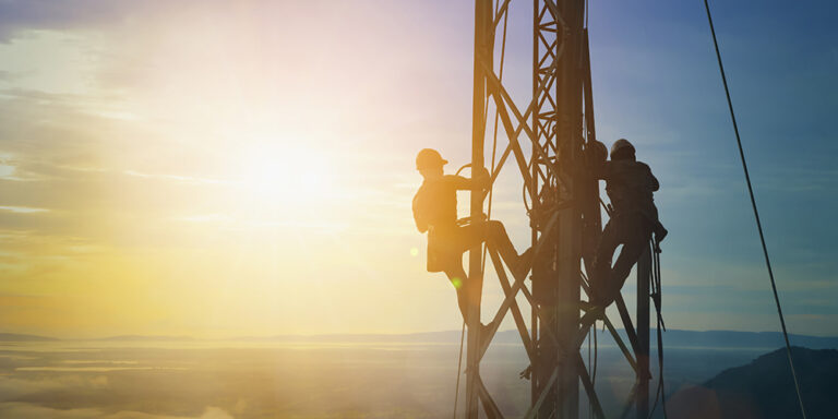 photo - Silhouette of electricians work on high ground