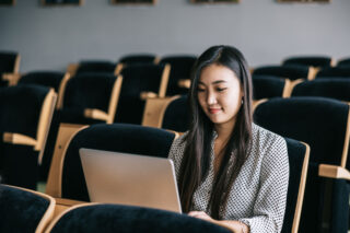 photo - University Student Looking at Laptop in Lecture Hall