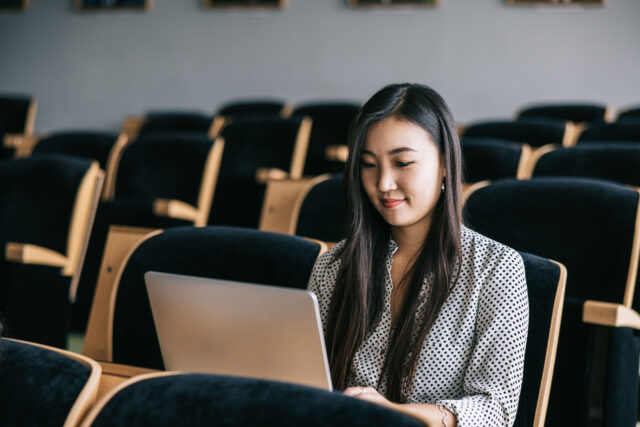 photo - University Student Looking at Laptop in Lecture Hall