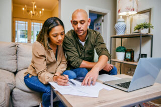 photo - Young Couple Reviewing Their Finances in Livingroom