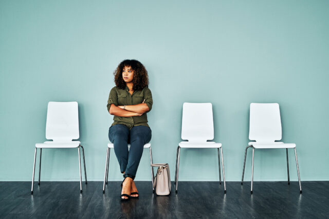 photo - Woman Waiting for Interview, Seated with Arms Crossed