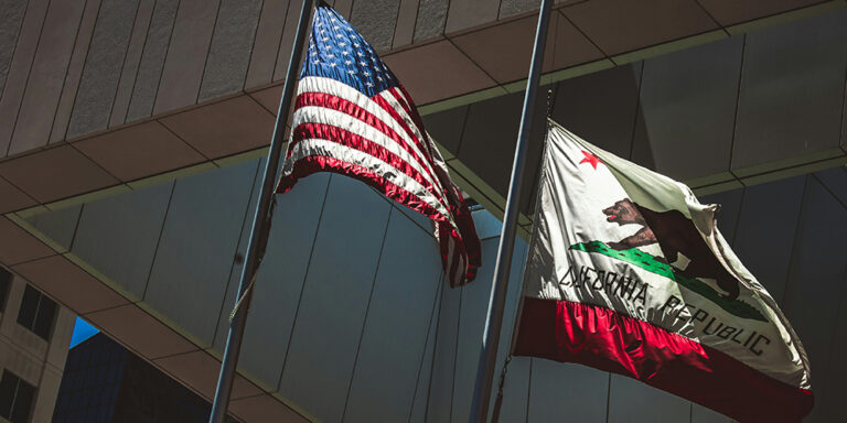 photo - American and California Flags Outside of a Government Building in Downtown San Diego