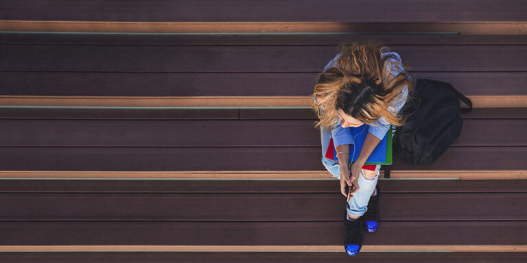photo - Student Girl on Campus Is Sitting on the Stairs