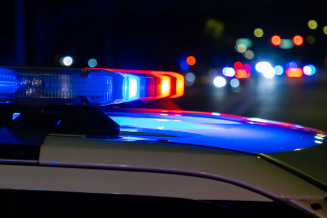 photo - Police Car with Blue and Red Lights on at Night