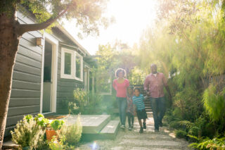 photo - African-American Parents with Two Children Walking in Garden