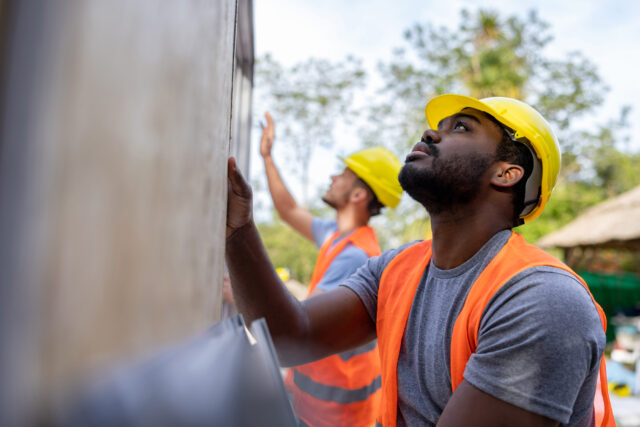 photo - Construction Workers Installing Panels while Building a Manufactured House