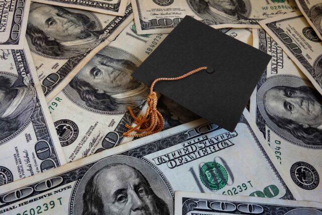 photo - Miniature Graduation Cap on Hundred Dollar Bills