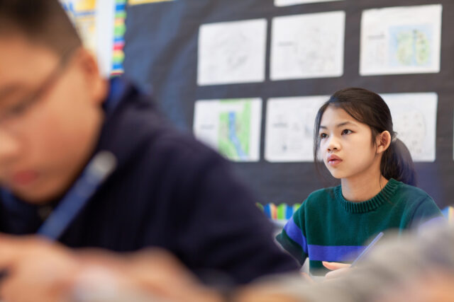 photo - Asian Elementary School Junior High Student Listens to Teacher in Classroom