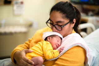 photo - Mother Holding Newborn Baby at Hospital