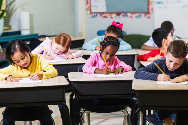 photo - Elementary School Students Sitting at Desks in Classroom Taking a Test