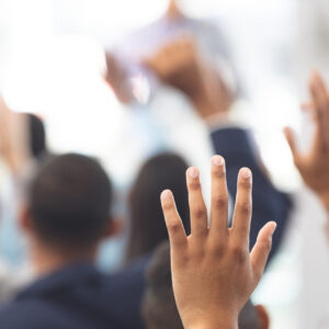 photo - Hands raised in a business seminar