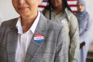 photo - Three People in a Line Wearing I Voted Stickers