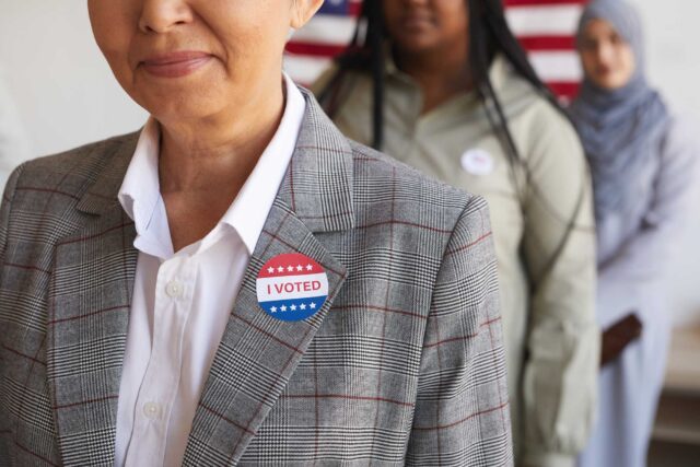 photo - Three People in a Line Wearing I Voted Stickers
