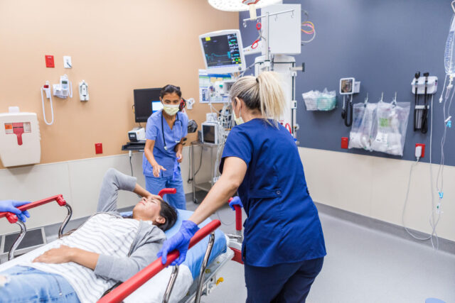 photo - Emergency Room Team Bringing Young Woman into Examination Room