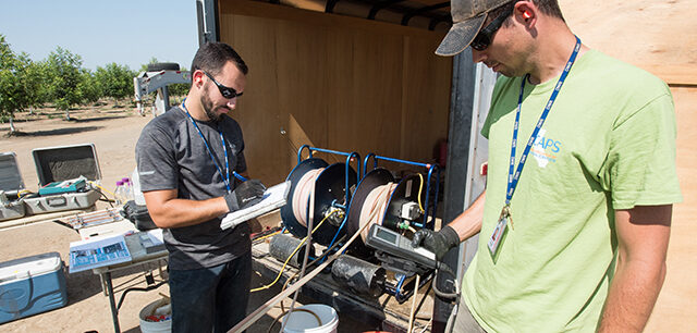 Fish and Wildlife Scientific Aid Brian Bettencourt (left) records data while Environmental Scientist Evan MacKinnon (right) reads off water quality parameters from a multi-parameter water quality meter at a well in Sutter County, California for the Department of Water Resources
