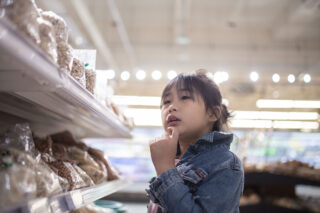 photo - Asian-American Girl Choosing Food in Supermarket