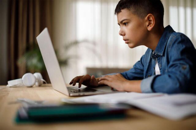 photo - Boy at Home Studying with Laptop