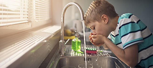 photo - Boy Drinking Water from Kitchen Faucet