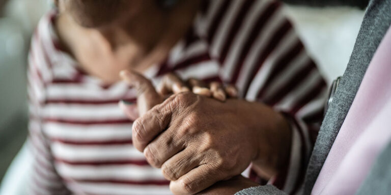photo - Caregiver and Senior Woman Holding Hands