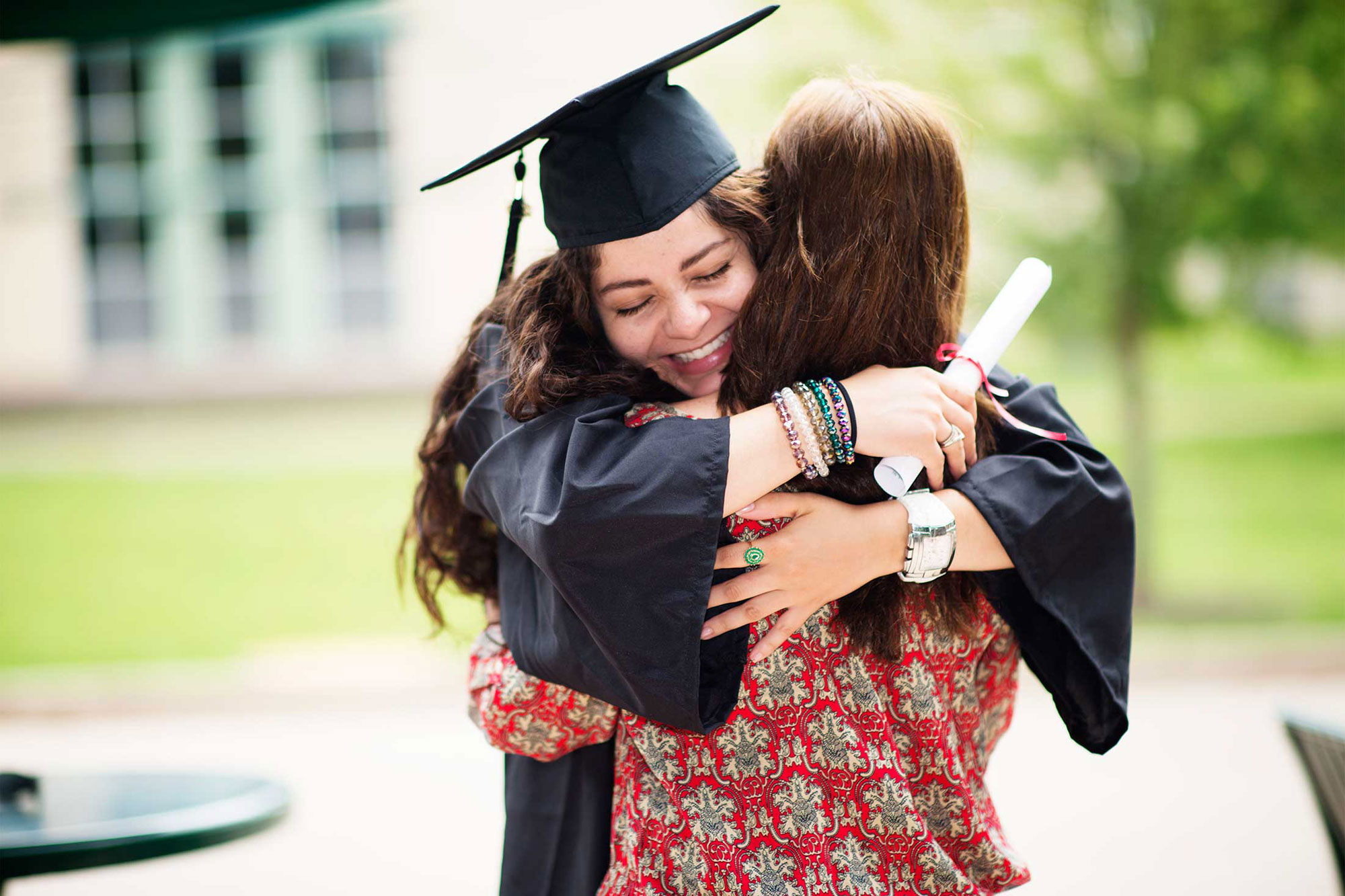 photo - College Graduate Hugging Mother and Holding Diploma