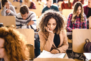 photo - College Student Studying Notes in Lecture Hall