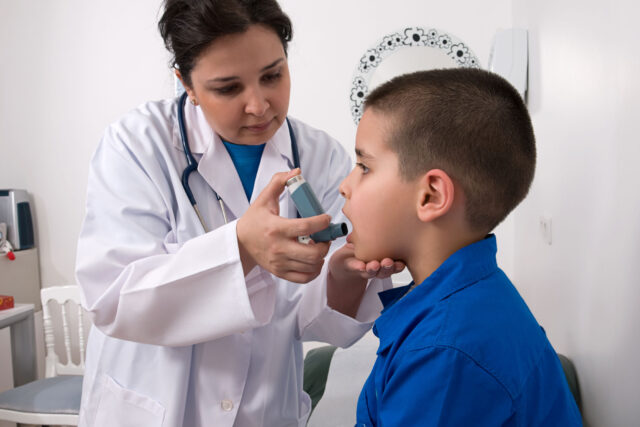 photo - Doctor Helping Boy with Asthma Inhaler